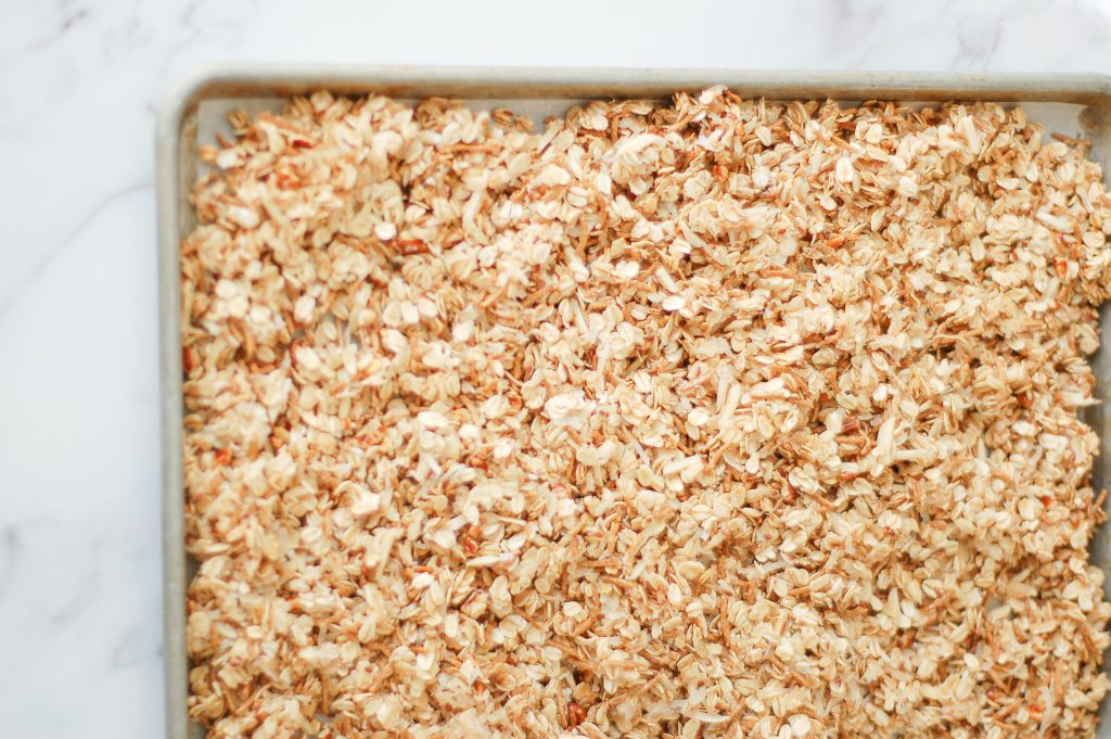 parchment lined baking sheet filled with homemade granola ready to bake