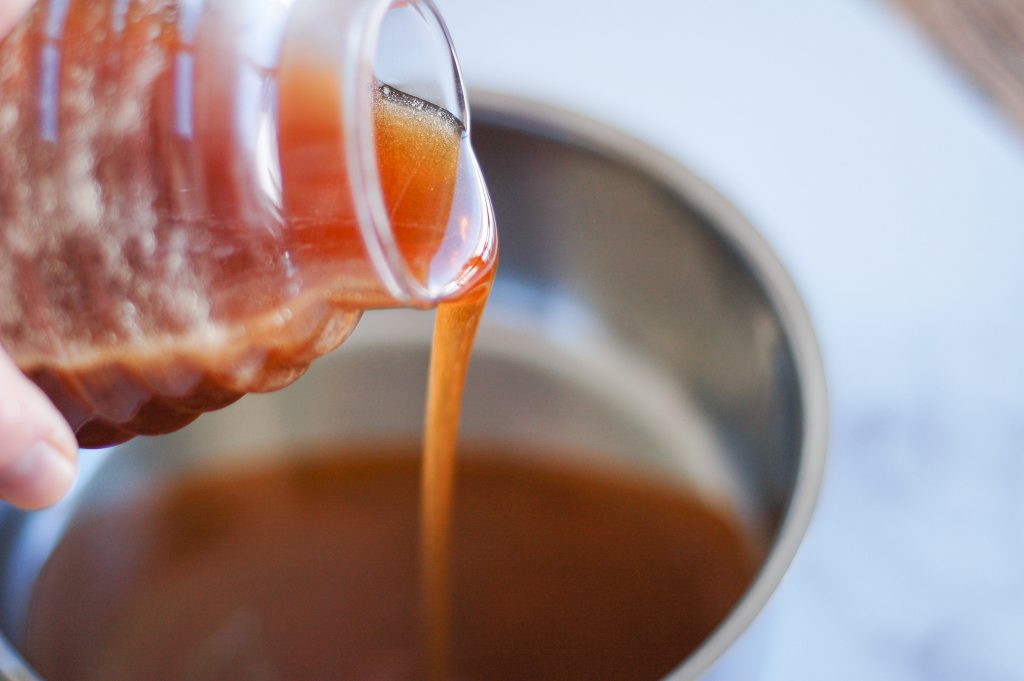 raw honey being added to a saucepan