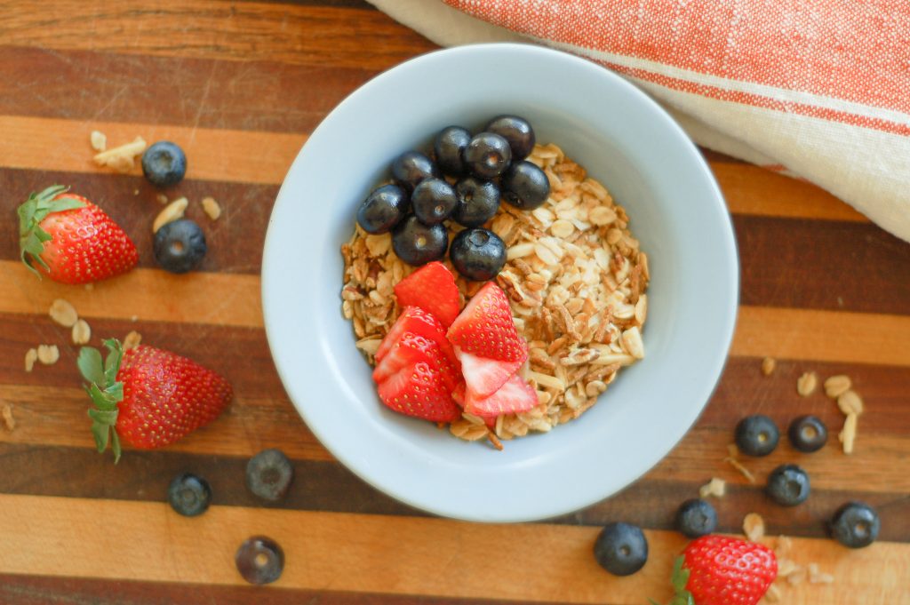 a bowl filled with homemade granola and fresh berries