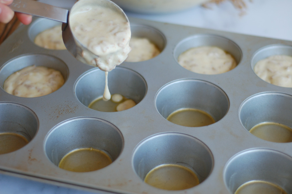 Adding buttermilk bran muffin batter to prepared muffin tins